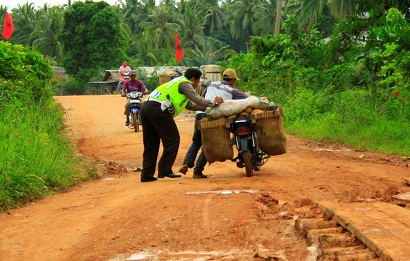 Anggota Polres Rohil tampak membantu pengendara sepeda motor yang kesulitan melintas di jalan lintas Bagansiapiapi menuju Sinaboi tepatnya di Kepenghuluan Parit Aman akibat kondisi jalan rusak berat