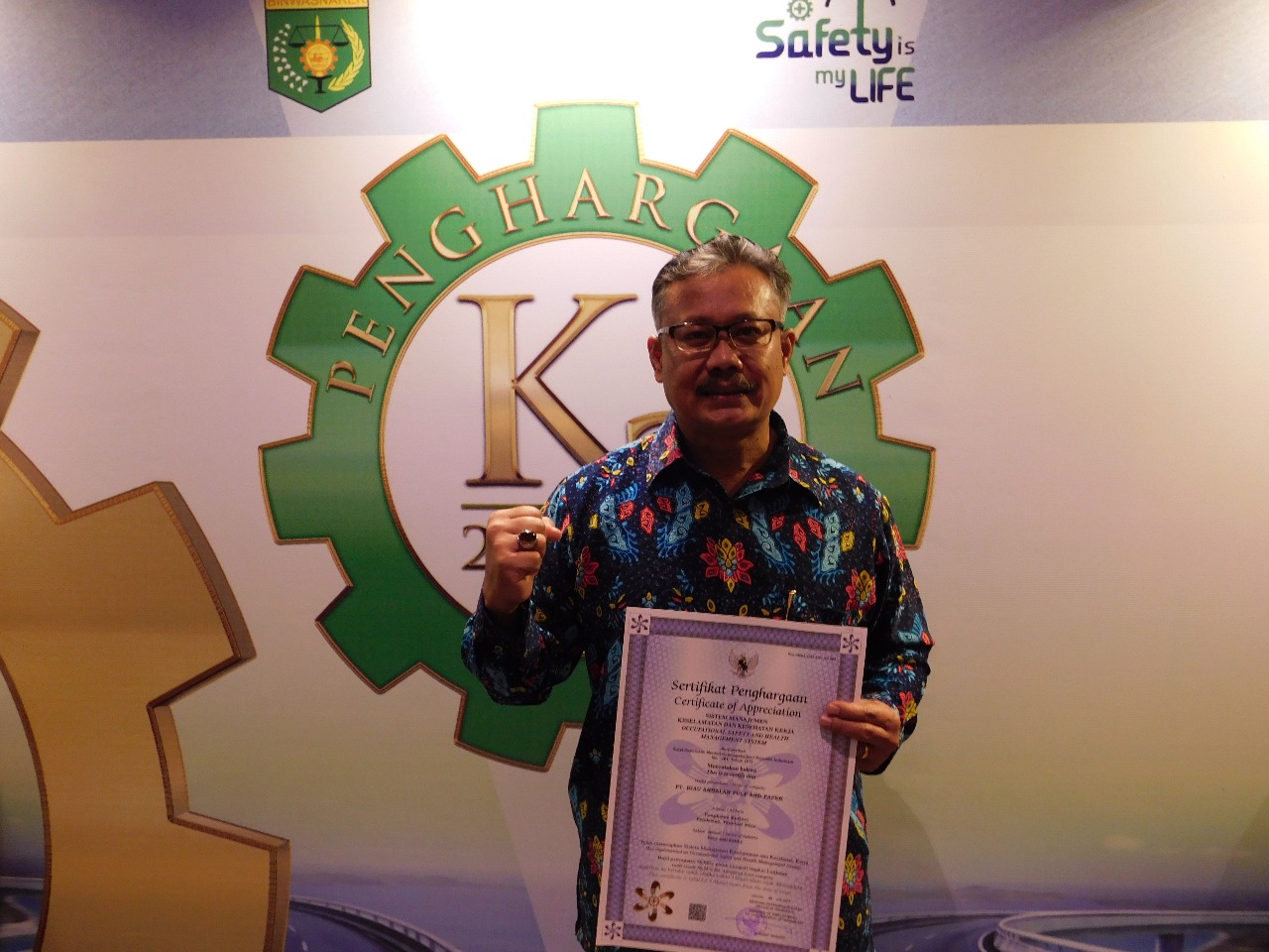 Loss Prevention & Control (LPnC) Head  PT RAPP , Robert L Sitorus berfoto dengan penghargaan Sertifikat dan Bendera Emas pada acara K3 Award.