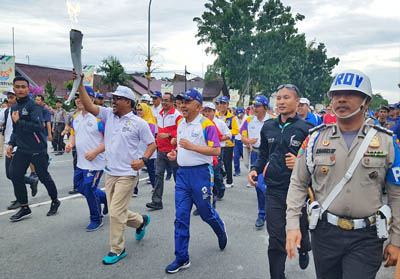  Direktur PT Riau Andalan Pulp and Paper (RAPP), Rudi Fajar ikut memegang dan membawa Api Obor, bersama Gubernur Riau, Arsyadjuliandi Rachman dan Forkompinda Riau, dalam Torch Relay Asian Games XVIII tahun 2018, Kamis (2/8/2018), di Pekanbaru.