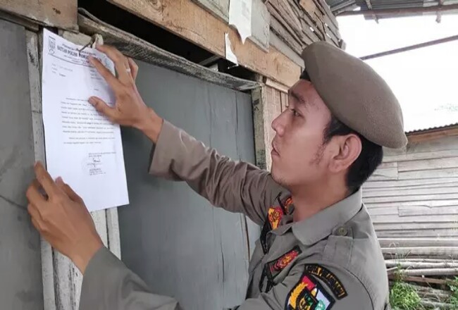 Satpol PP Pekanbaru memasang surat peringatan kepada warung remang-remang yang belum dibongkar pemiliknya. Foto: Antara