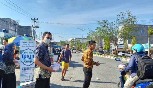 Duta BPJS Kesehatan Cabang Dumai membagikan takjil kepada warga yang melintas di Jalan Jenderal Sudirman (foto/ist)