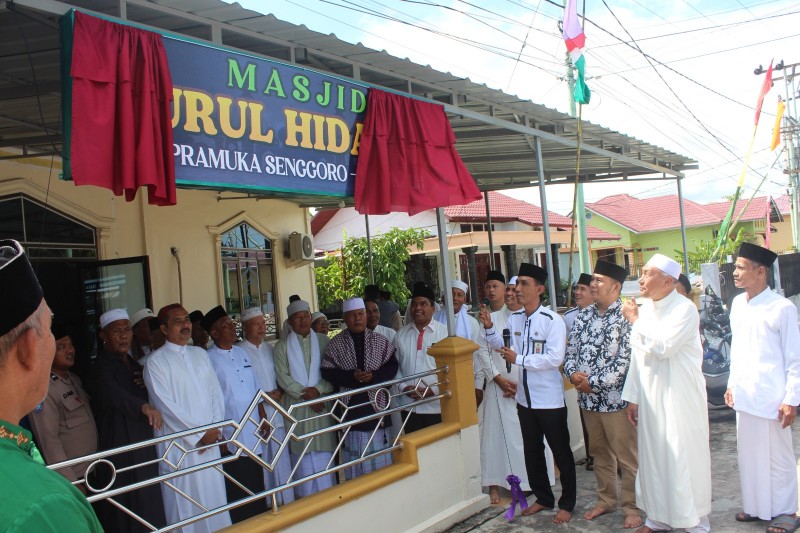 Pengurus menarik tirai seremoni Musala Nurul Hidayah di Desa Senggoro menjadi mesjid (foto/Zulkarnain)