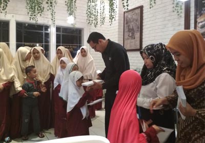    Operational Manager Warung Koffie Batavia, Riko Rinaldo (kemeja hitam) bagi santunan kepada puluhan anak yatim usai buka bersama di Warung Koffie Batavia, Mal Pekanbaru, Selasa (12/6/2018).