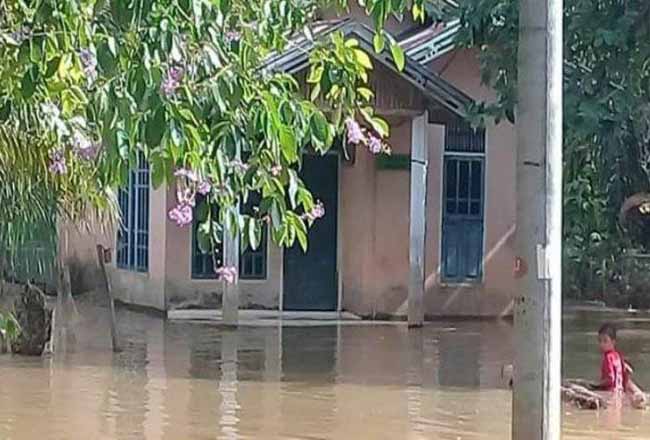 Kondisi banjir yang terjadi di Kecamatan Pangean, Kuansing. Terlihat sejumlah rumah tergenang dan ada warga yang berada di tengah banjir. Foto: Tribunpekanbaru