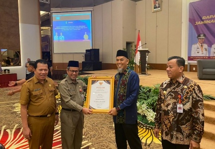 Walikota Dumai H Paisal menerima penghargaan UHC yang diserahkan oleh Asisten I Setdaprov Riau Masrul Kasmy di PPekanbaru (foto/Bam)