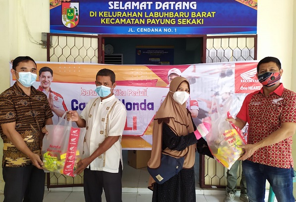Arman Situmeang Manager Serivce dan Toni Hadi Wibowo Manager Honda Customer Care PT CDN Riau memberikan sembako kepada warga Labuh Baru Barat