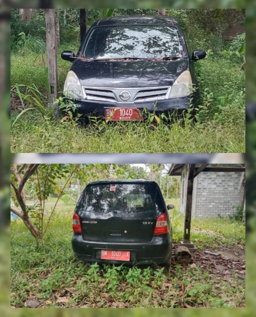 Sebuah mobil dinas Pemkab Kepulauan Meranti teronggok dan terbengkalai di belakang rumah warga