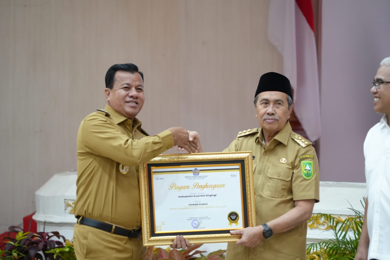 Plt Bupati Kuansing Suhardiman Amby menerima piagam penghargaan diserahkan Gubri Syamsuar (foto/san)