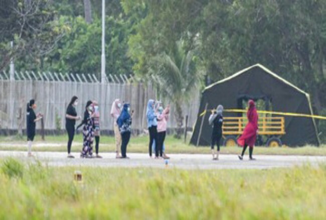 Sejumlah Warga Negara Indonesia (WNI) asal Wuhan, Hubei, China beraktivitas di depan Hanggar Pangkalan Udara Raden Sadjad, Ranai, Natuna, Kepulauan Riau. Foto: CNNIndonesia