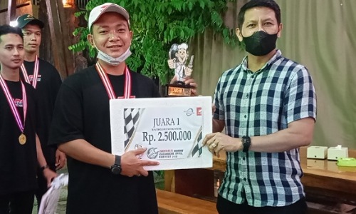 Arman Situmeang Technical Service Manager PT CDN Riau menyerahkan hadiah trofi dan uang tunai kepada pemenang pertama Kontes Mekanik & Service Advisor kategori Mekanik.(foto: istimewa)