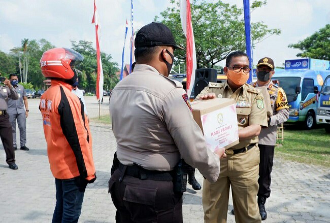 Polda Riau peduli Covid-19 menyerahkan bantuan untuk masyarakat.