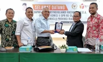 Andi Rachman menerima cinderamata dari ketua Bawaslu Riau