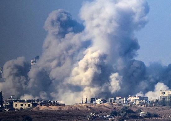 Kepulan asap menjulang ke udara saat Jalur Gaza kembali digempur serangan Israel pada Jumat (1/12). (Foto: AFP/JOHN MACDOUGALL)
