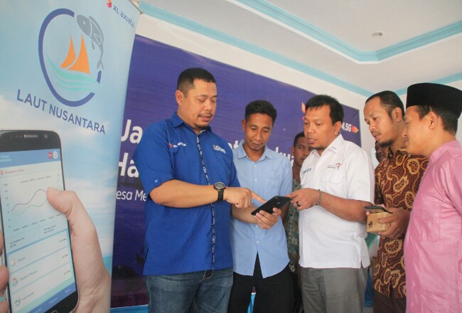 Head of Sales Kepri dan Ridar XL Axiata, Alex Burnama menunjukkan aplikasi Laut Nusantara kepada Kepala Dinas Kominfo Natuna, Raja Darmika dan nelayan Desa Mekar Jaya, Kabupaten Natuna, Jumat (20/12). 
