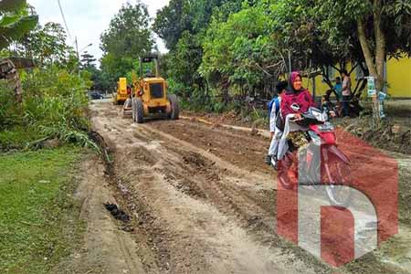 Alat berat Dinas PUPR Rohul perbaiki jalan rusak di Kelurahan Kota Tengah, kecamatan Kepenuhan, setelah didesaak warga untuk diperbaiki.