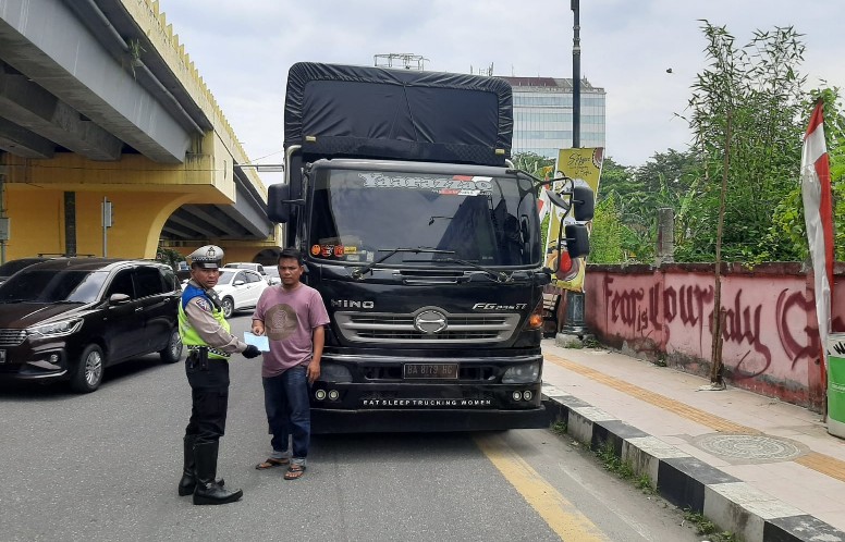 Pihak kepolisian didampingi Dishub Pekanbaru memberikan tilang terhadap pengemudi truk yang melanggar (foto/rahmat)