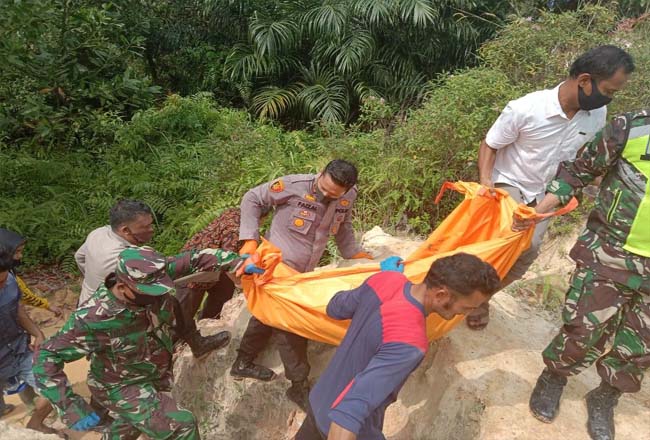 Evakuasi jasad korban Aprianus (8) di tebing kebun sawit milik warga di Kampung Pinang Sebatang Timur, Kabupaten Siak, Jumat (17/7/2020). Foto: Riaupos