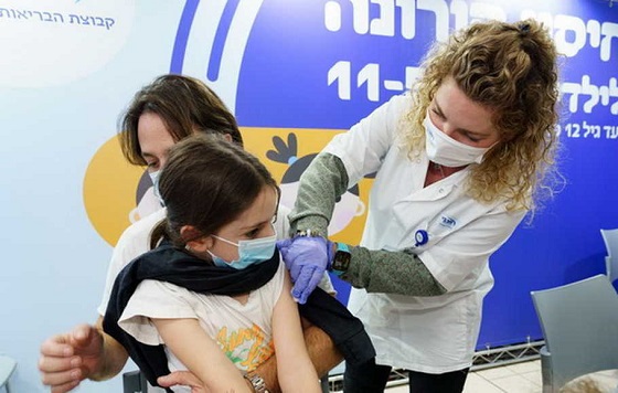 Seorang anak menerima vaksin Covid-19 di tempat vaksinasi di Ramat Hasharon, Israel, Senin 22 November 2021. (Foto: Xinhua/JINI)
