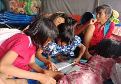 Anak-anak yang sedang belajar di tenda pengungsian.
