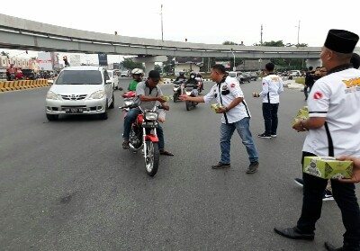 Pembagian takjil bagi pengendara yang melintas di simpang Pasar Pagi Arengka Pekanbaru.