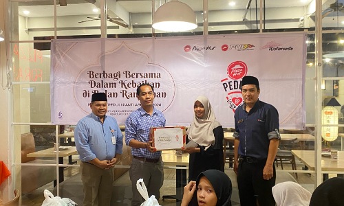 Penyerahan bantuan secara simbolis dari Pizza Hut Indonesia Sudirman Pekanbaru kepada Panti Asuhan Fajar Harapan.(foto: sri/halloriau.com)
