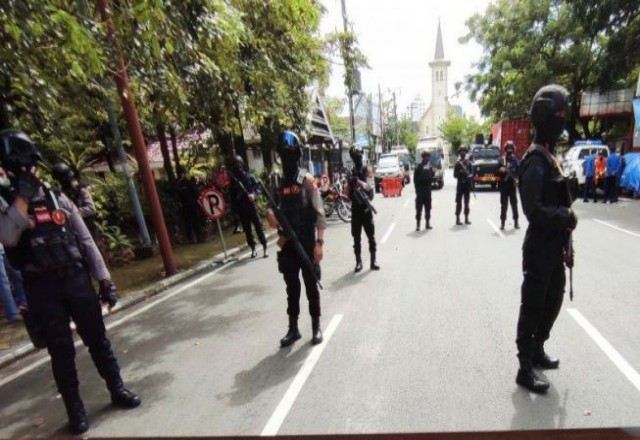 Polisi bersenjata lengkap mengamankan lokasi setelah ledakan bom bunuh diri di gerbang Gereja Katedral, di Jalan Kajaolalido, Kecamatan Ujungpandang, Kota Makassar. Foto: Antara
