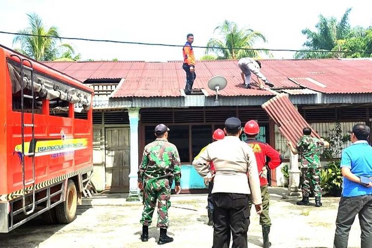 Tim gabungan bergotong royong memperbaiki sejumlah rumah warga dan sekolah yang dilanda puting beliung di Rohul.(foto: kompas.com)