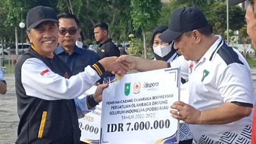 Gubernur Riau, Syamsuar menyerahkan penghargaan berupa uang pembinaan kepada SF Hariyanto selaku Ketua Pengprov Podsi Riau dalam peringatan Haornas ke-40.(foto: rahmat/halloriau.com)