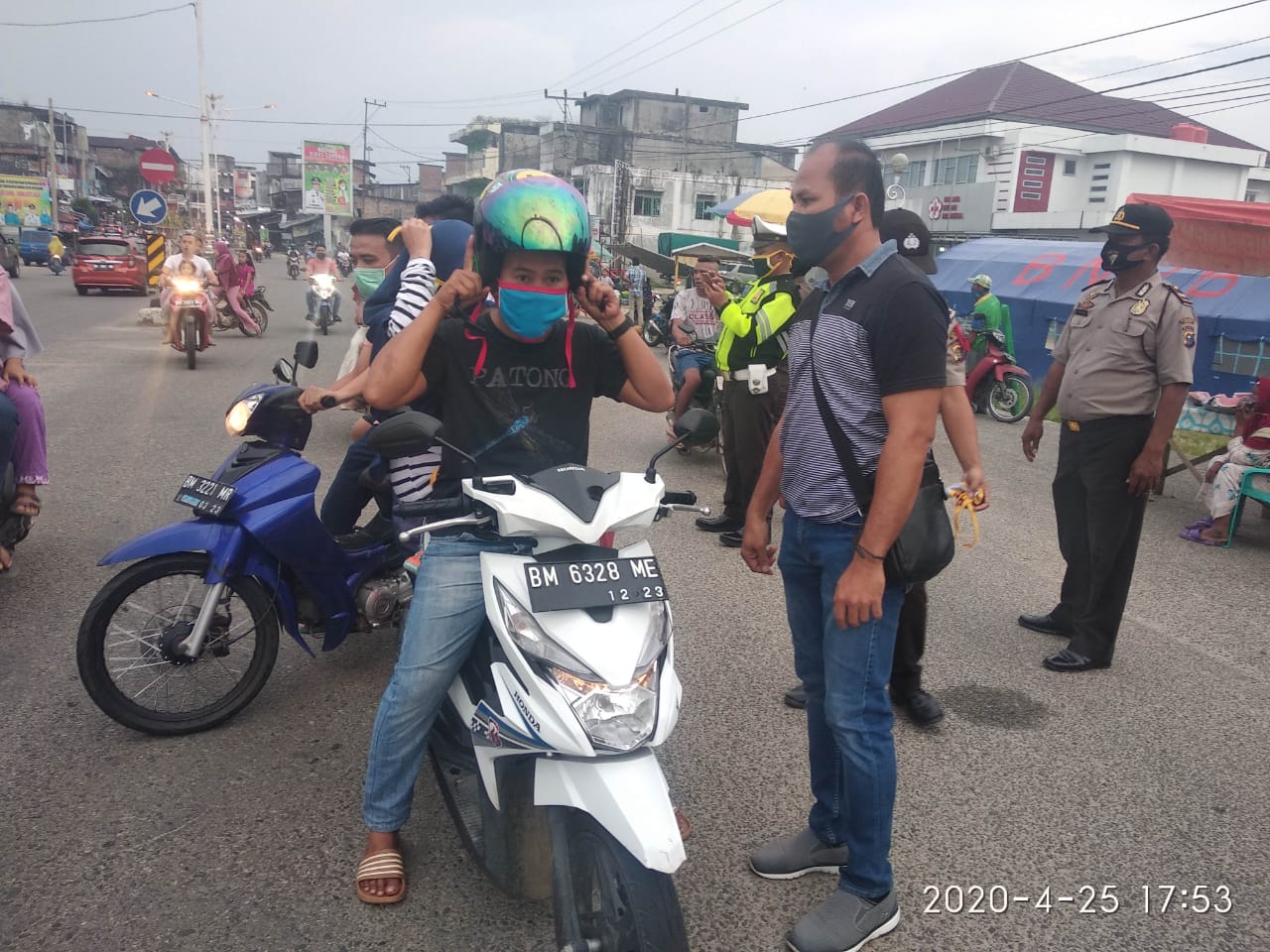 Petugas gabungan Polres Rohul dan Satpol PP, bagikan masker ke masyarakat yang tidak kenakan masker saat akan belanja takjil berbuka puasa di Jalan Diponegoro, Kelurahan Pasir Pangaraian 