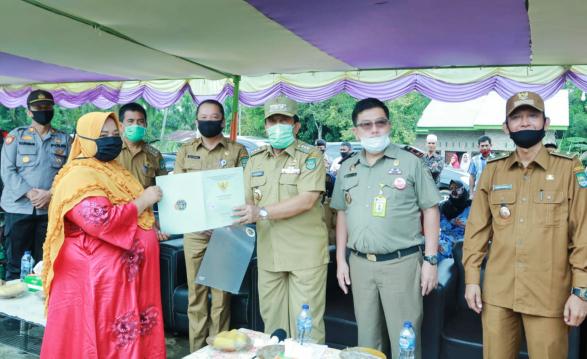 Bupati Sukiman didampingi Kepala ATR/ BPN, Camat Tambusai, Kades Sukamaju, serahkan simbolis sertifikat program TORA kepada masyarakat. 