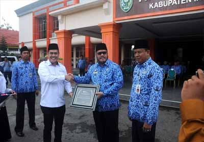 Bupati H Yopi Arianto SE saat menerima penghargaan dari BPJS Ketenagakerjaan