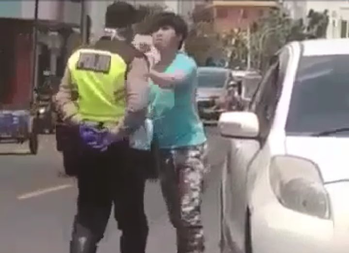 Tangkapan layar dari video yang memperlihatkan seorang polisi lalu lintas meludahi pengemudi mobil di Jalan MT Haryono, Medan, Sumatera Utara, Sabtu (11/4/2020). 