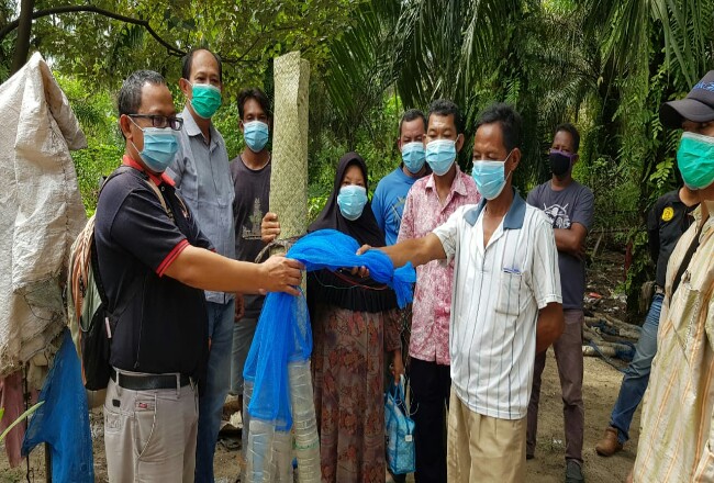 Kepala Forest Protection Sudarta disaksikan Kepala Program DMPA/CD CSR PT Arara Abadi Jos Rinaldi, ketika menyerahkan alat Bubu Belut Kepada Masyarakat Sakai Bathin Beringin.
