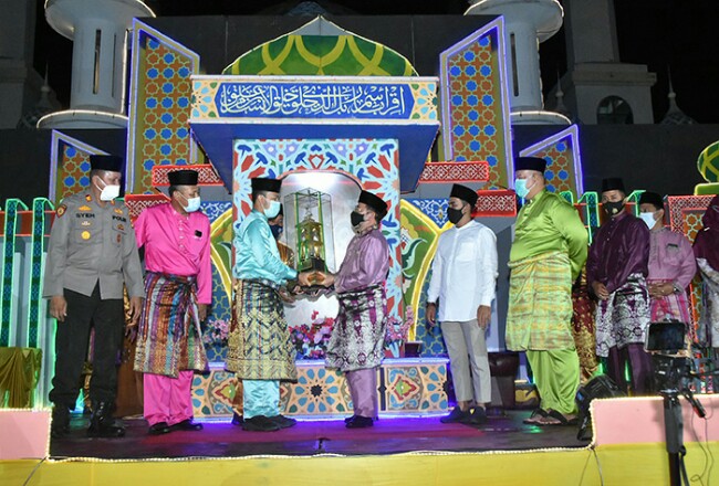 Sekda Bengkalis Bustami HY menyerahkan piala bergilir juara umum MTQ Tingkat Kabupaten Bengkalis kepada Camat Bengkalis Ade Suwirman.