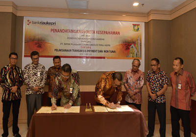   Bupati Kampar H. Aziz Zaenal, SH, MM menandatangani MoU tentang pelaksanaan E-Payment dan transaksi non tunai bersama Dirut Bank Riau Kepri DR. Irvandi Gustari, Selasa (20/3/18) di Batam.