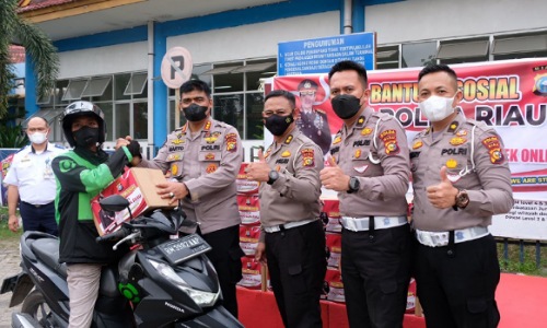 Kabid Humas Polda Riau, Kombes Pol Sunarto menyerahkan paket sembako kepada driver ojol Pekanbaru di Terminal AKAP Pekanbaru.(foto: istimewa)