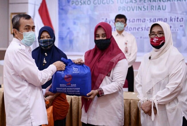 Gubri Syamsuar menyerahkan bantuan secara simbolik pada 10 kabupaten/kota di Provinsi Riau.