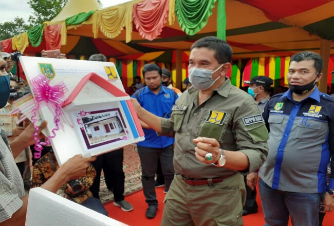 Kadis Perkim Rohil, Zulfahmi ST MT didampingi Kepala BPPW Riau, menyerahkan rumah layak huni secara simbolis disela peresmian Pamsimas III di Serusa.