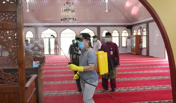 Walikota Dumai H. Zulkifli AS menyemprot cairan disinfektan di Masjid Habiburrahman.