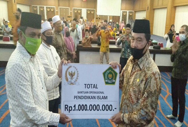 Anggota Komisi VIII DPR/MPR RI Drs Achmad MSi, menyerahkan secara simbolis ke Kakan Kemenag Rohul Syahrudin bantuan Op Rp1 miliar.