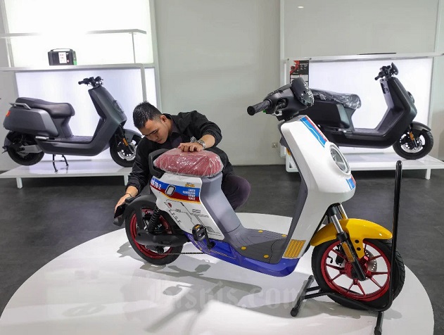 Pegawai merapikan sepeda motor listrik di salah satu ruang pamer/showroom, Jakarta, Senin (30/1/2023).