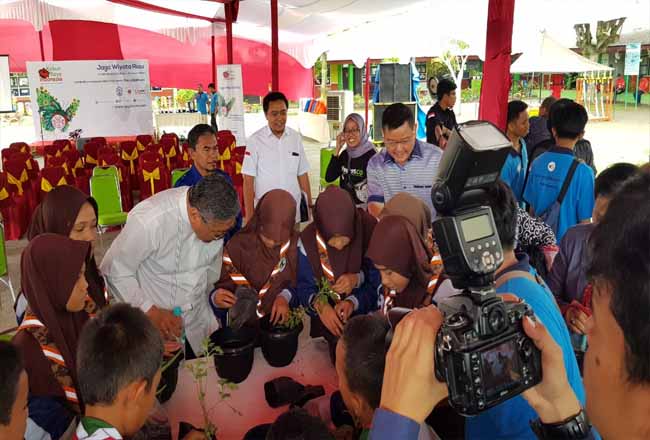 Direktur IKPP Hasanuddin The bersama Ketua Yayasan Kebun Raya Indonesia Michael memperhatikan anak SD untul praktek tanaman TOGA (Tanaman Obat Keluraga).