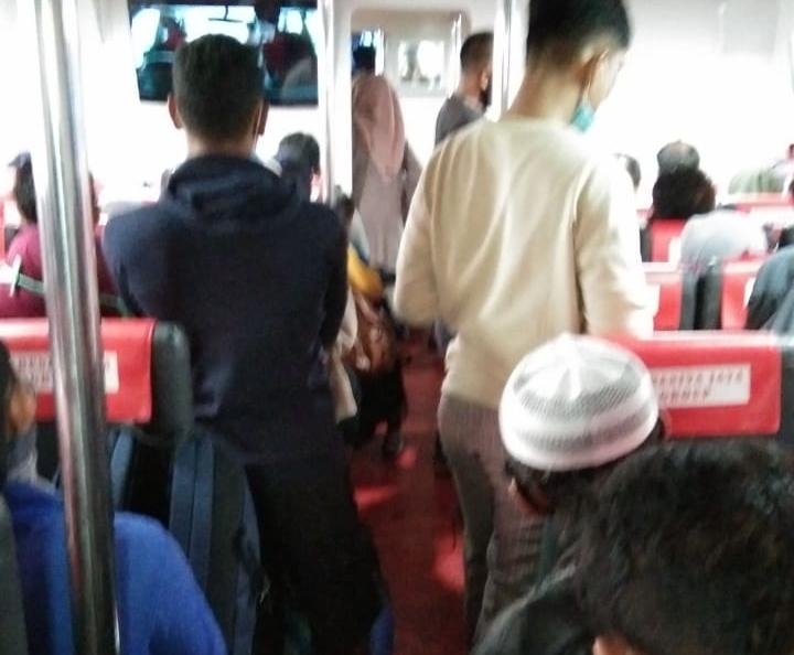 Tampak tak ads kursi kosong sebagai bentuk sosial distancing. Malah ada penumpang berdiri dan masih ada yang tidak mengenakan masker.
