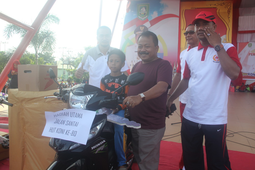 Asisten II H Heri Indra Putra bersama Febriansyah, pemenang hadiah utama jalan santai sempena HUT KONI ke-80 berupa satu unit sepedamotor.