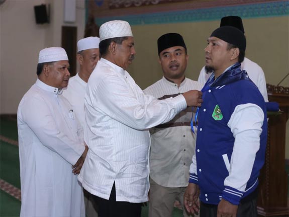 Bupati Alfedri secara simbolis memasangkan jaket dan dan tanda pengenal kepada jamaah calon haji Kabupaten Siak,