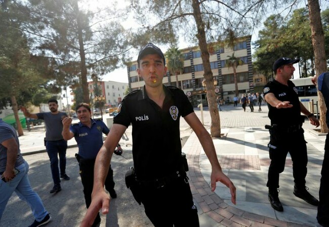 Polisi mencoba mencegah warga untuk tidak mendekati Gedung Pemerintahan Akcakale, Turki. Foto: Kompas