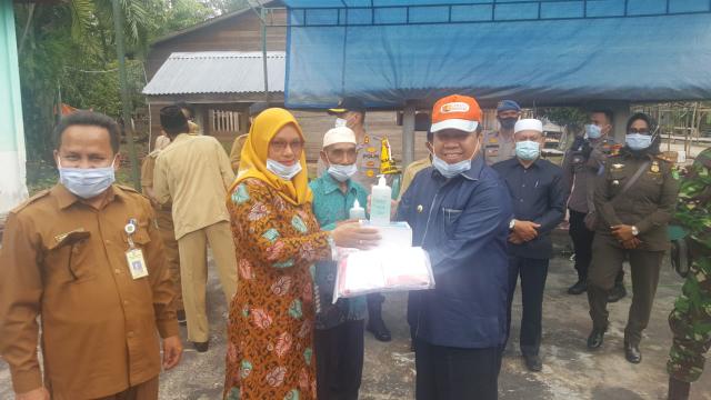 Bupati Kepulauan Meranti, Drs H Irwan menyerahkan bantuan APD dan hand sanitizer ke petugas di Desa Tanjung Peranap.