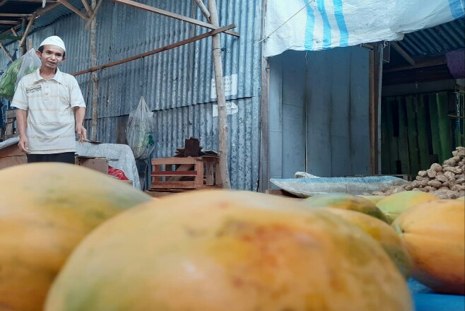 Edi, seorang pedagang sayuran dan buah - buahan di Pasar Cik Puan, Jalan Nangka, Pekanbaru.