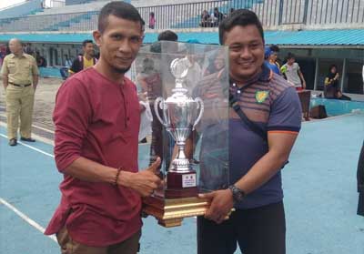Bengkalis juara umum Kejurda Atletik Riau, tampak pengurus PASI Bengkalis, Aries mengangkat tropy juara