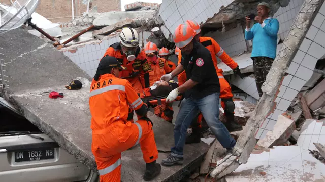 Tim penyelamat membawa korban selamat dari sebuah bangunan restoran yang rusak akibat gempa dan tsunami yang menghantam Palu, Sulawesi Tengah. Foto : Liputan6